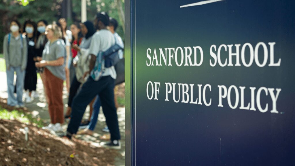 Sanford School sign in foreground, students out of focus